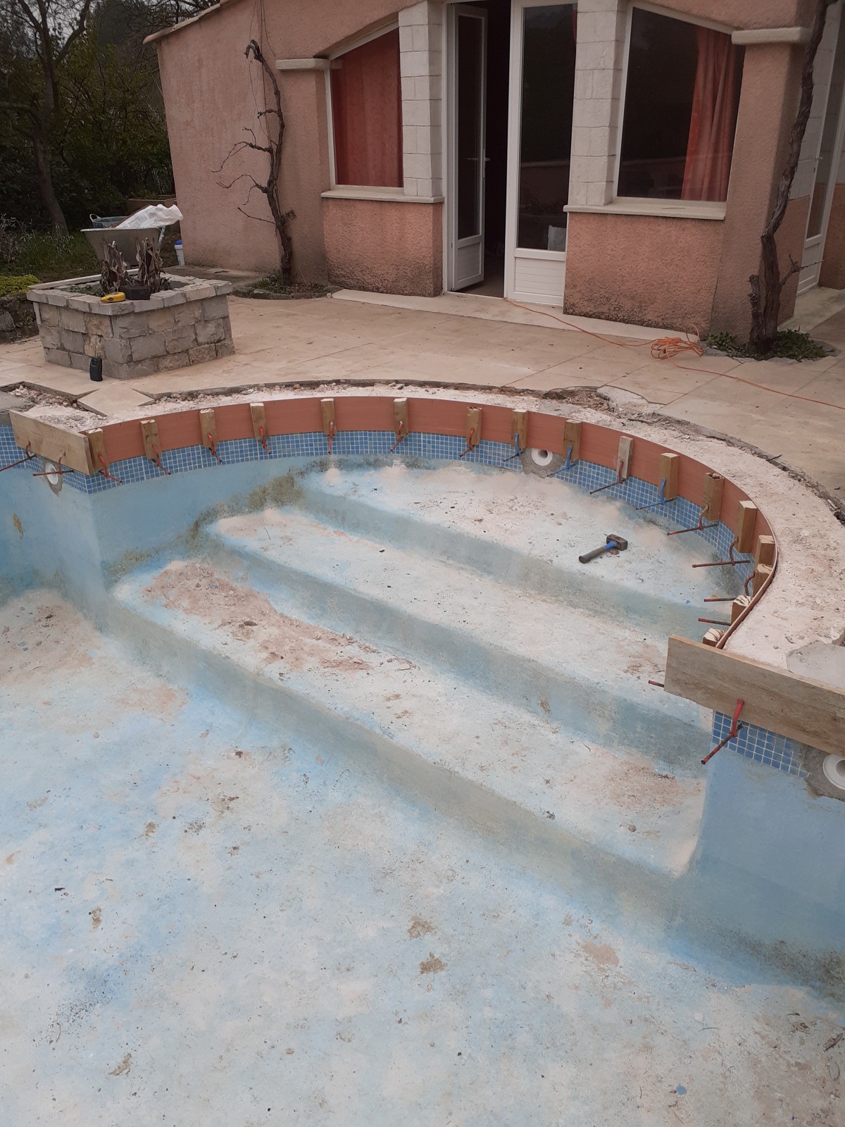 Rénovation complète d’une piscine en béton à Cuges-les-Pins proche d'Aubagne avec rehaussement et pose de margelles en travertin et PVC armé