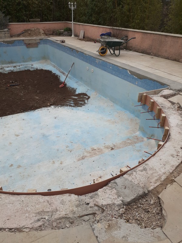 Rénovation complète d’une piscine en béton à Cuges-les-Pins proche d'Aubagne avec rehaussement et pose de margelles en travertin et PVC armé